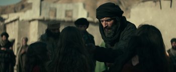 Movie still from “12 Strong” (2018), directed by Nicolai Fuglsig – A man with a long beard and a turban on his head; Medium shot, Over the shoulder angle