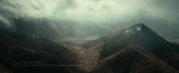 Movie still from “12 Strong” (2018), directed by Nicolai Fuglsig – A view of a valley with a cloudy sky above it; Extreme Wide shot, High angle