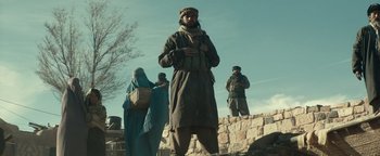 Movie still from “12 Strong” (2018), directed by Nicolai Fuglsig – A group of people standing on top of a stone wall; Medium shot, Low angle