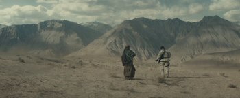 Movie still from “12 Strong” (2018), directed by Nicolai Fuglsig – Two men in the desert looking out at the mountains; Extreme Wide shot, High angle
