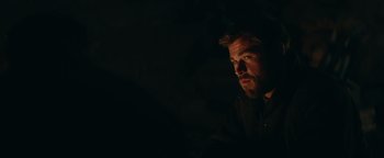Movie still from “12 Strong” (2018), directed by Nicolai Fuglsig – A person in a dark room; Close Up shot, Over the shoulder angle
