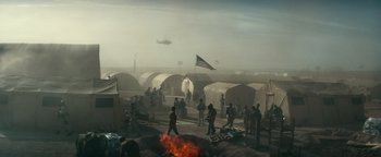 Movie still from “12 Strong” (2018), directed by Nicolai Fuglsig – A group of people standing next to a fire pit; Extreme Wide shot, High angle