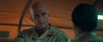 Movie still from “12 Strong” (2018), directed by Nicolai Fuglsig – A man in a military uniform is looking at the camera; Close Up shot, Over the shoulder angle