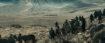 Movie still from “12 Strong” (2018), directed by Nicolai Fuglsig – A group of people walking through a field; Extreme Wide shot, High angle