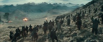 Movie still from “12 Strong” (2018), directed by Nicolai Fuglsig – A group of people riding horses down a hill; Extreme Wide shot, High angle