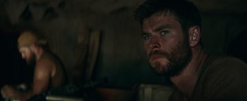 Movie still from “12 Strong” (2018), directed by Nicolai Fuglsig – A person with a beard and blue eyes; Close Up shot, Over the shoulder angle