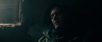 Movie still from “12 Strong” (2018), directed by Nicolai Fuglsig – A man in a hooded jacket looking down at the ground; Close Up shot, Low angle