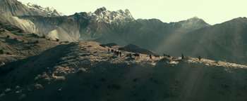 Movie still from “12 Strong” (2018), directed by Nicolai Fuglsig – A herd of cattle grazing on a grassy hillside; Extreme Wide shot, High angle