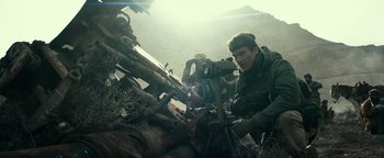 Movie still from “12 Strong” (2018), directed by Nicolai Fuglsig – A man in the woods looking at a camera; Medium shot, Low angle