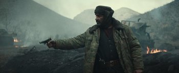 Movie still from “12 Strong” (2018), directed by Nicolai Fuglsig – A man in a camouflage jacket pointing to the ground; Medium shot, Low angle