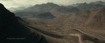Movie still from “12 Strong” (2018), directed by Nicolai Fuglsig – An aerial view of a large city in the middle of the desert; Extreme Wide shot, High angle