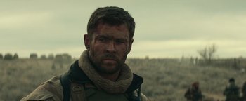 Movie still from “12 Strong” (2018), directed by Nicolai Fuglsig – A person with a scarf on; Close Up shot, Over the shoulder angle