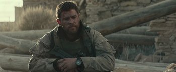Movie still from “12 Strong” (2018), directed by Nicolai Fuglsig – A man with a watch sitting on the ground; Close Up shot, Over the shoulder angle