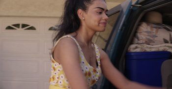 Movie still from “Dramarama” (2020), directed by Jonathan Wysocki – A woman in a yellow and white floral dress; Close Up shot, Over the shoulder angle