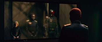 Movie still from “Dredd” (2012), directed by Pete Travis – A man and a woman in uniform in a room; Medium shot, Over the shoulder angle