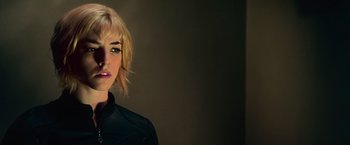 Movie still from “Dredd” (2012), directed by Pete Travis – A woman with blonde hair wearing a black shirt; Close Up shot, Low angle
