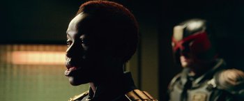 Movie still from “Dredd” (2012), directed by Pete Travis – A person's face in a dark room; Close Up shot, Over the shoulder angle