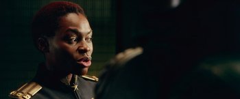 Movie still from “Dredd” (2012), directed by Pete Travis – A man in a military uniform looking at the camera; Close Up shot, Over the shoulder angle