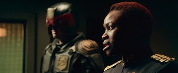 Movie still from “Dredd” (2012), directed by Pete Travis – A man and a woman in a helmet and uniform; Close Up shot, Over the shoulder angle