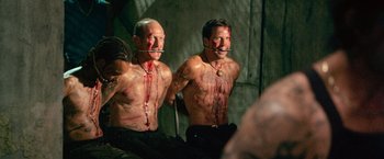 Movie still from “Dredd” (2012), directed by Pete Travis – Two shirtless men with blood all over their bodies; Medium shot, High angle