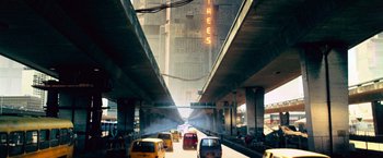 Movie still from “Dredd” (2012), directed by Pete Travis – A city street filled with lots of traffic under a bridge; Extreme Wide shot, Low angle