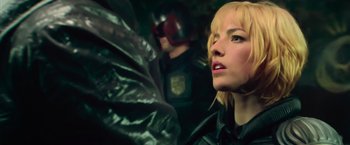 Movie still from “Dredd” (2012), directed by Pete Travis – A woman with blonde hair wearing a leather jacket; Close Up shot, Low angle