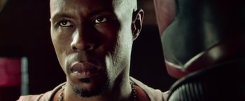 Movie still from “Dredd” (2012), directed by Pete Travis – A man's face in a dark room; Close Up shot, Low angle