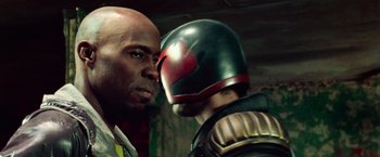 Movie still from “Dredd” (2012), directed by Pete Travis – A man and a man in a helmet face to face; Close Up shot, Over the shoulder angle