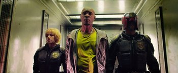 Movie still from “Dredd” (2012), directed by Pete Travis – A group of men standing next to each other; Medium shot, Low angle