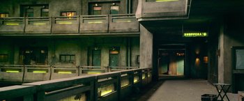 Movie still from “Dredd” (2012), directed by Pete Travis – A building that has been painted green and has been lit up with green lights; Extreme Wide shot, High angle