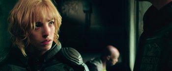 Movie still from “Dredd” (2012), directed by Pete Travis – A woman with blonde hair and a bald head; Close Up shot, Over the shoulder angle