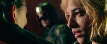 Movie still from “Dredd” (2012), directed by Pete Travis – Two people in a room with a helmet on; Close Up shot, Low angle