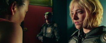 Movie still from “Dredd” (2012), directed by Pete Travis – A man and a woman in a room with red walls; Close Up shot, Over the shoulder angle