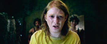 Movie still from “Dredd” (2012), directed by Pete Travis – A young woman with red hair and a yellow shirt; Close Up shot, High angle