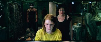 Movie still from “Dredd” (2012), directed by Pete Travis – Two women and a man are in a room; Medium shot, Over the shoulder angle