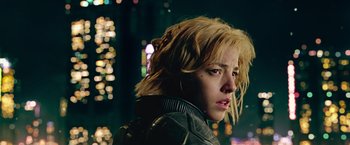 Movie still from “Dredd” (2012), directed by Pete Travis – A person wearing a jacket with lights in the background; Close Up shot, Low angle