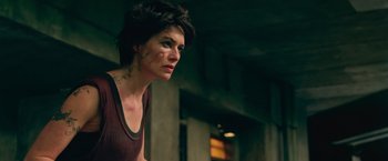 Movie still from “Dredd” (2012), directed by Pete Travis – A person with a tattoo on her face; Close Up shot, Over the shoulder angle