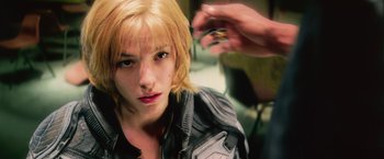 Movie still from “Dredd” (2012), directed by Pete Travis – A woman getting her hair cut by a stylist; Close Up shot, Over the shoulder angle