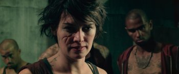 Movie still from “Dredd” (2012), directed by Pete Travis – A person with tattoos on their face; Close Up shot, Over the shoulder angle