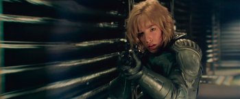 Movie still from “Dredd” (2012), directed by Pete Travis – A woman with blonde hair is holding a gun; Close Up shot, Low angle