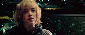 Movie still from “Dredd” (2012), directed by Pete Travis – A woman with blonde hair wearing a space suit; Close Up shot, Low angle