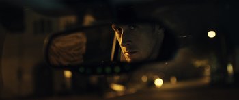 Movie still from “Drive” (2011), directed by Nicolas Winding Refn – A person in a car looking into a mirror; Close Up shot, Low angle