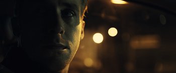 Movie still from “Drive” (2011), directed by Nicolas Winding Refn – A man's face in the dark; Close Up shot, Low angle