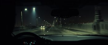 Movie still from “Drive” (2011), directed by Nicolas Winding Refn – A view from a car of a bridge at night; Extreme Wide shot, High angle