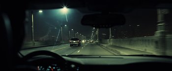 Movie still from “Drive” (2011), directed by Nicolas Winding Refn – A view from a car of a highway at night; Wide shot, High angle