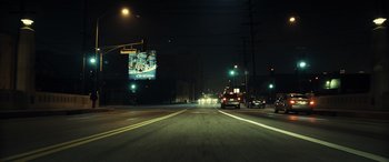 Movie still from “Drive” (2011), directed by Nicolas Winding Refn – Cars driving down a street at night under a lit up sign; Extreme Wide shot, Low angle