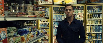 Movie still from “Drive” (2011), directed by Nicolas Winding Refn – A man standing in front of a display case; Medium shot, Over the shoulder angle