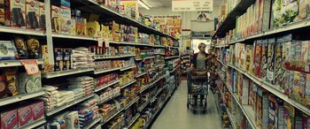 Movie still from “Drive” (2011), directed by Nicolas Winding Refn – A woman pushing a shopping cart in a grocery store aisle; Wide shot, Low angle