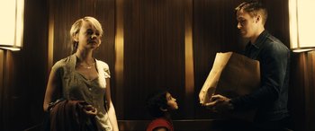 Movie still from “Drive” (2011), directed by Nicolas Winding Refn – A woman standing next to a boy in an elevator; Medium shot, Low angle
