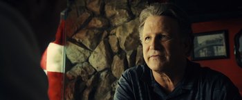 Movie still from “Drive” (2011), directed by Nicolas Winding Refn – An older man sitting in front of a stone wall; Close Up shot, Low angle